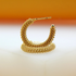A pair of textured gold hoop earrings rests on a reflective white surface against a warm orange backdrop.