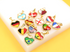 A collection of gold-framed heart-shaped country flag charms rests on a white display block.