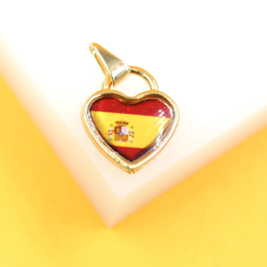 A gold-trimmed heart-shaped pendant showcases the red and yellow Spanish flag enamel design.