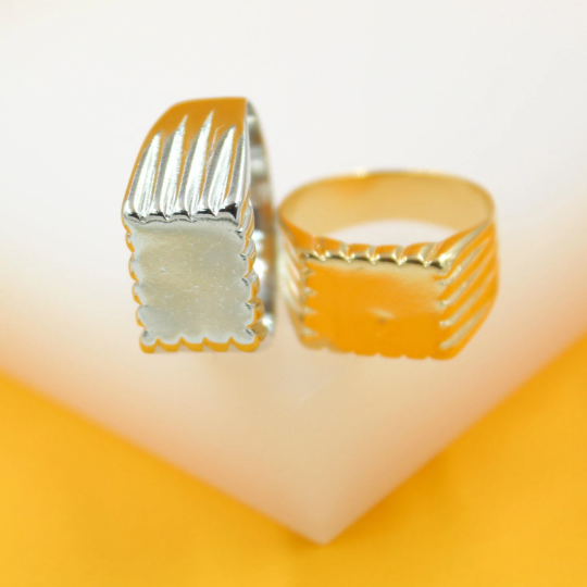 Two unique rings featuring fluted designs rest on a bright white and yellow surface.