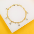 A delicate gold chain bracelet features sparkling crystal charms dangling against a white and yellow background.