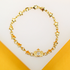 A gold charm bracelet featuring alternating star links and a central crown charm encrusted with cubic zirconia stones is displayed on a light surface.