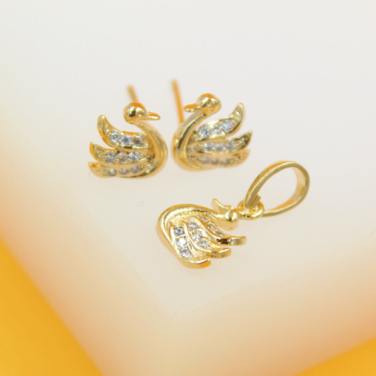 A matching set of gold swan earrings and a pendant features sparkling cubic zirconia stones embedded in the wings.