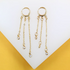 A pair of elegant gold hoop earrings featuring dangling chains accented with sparkling cubic zirconia stones is displayed against a white and yellow background.
