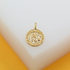 A gleaming gold Saint Christopher pendant rests on a minimalist white surface.