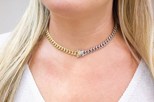 A blonde woman wears a two-tone Miami Cuban link choker necklace featuring half yellow gold and half silver links.
