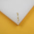 A delicate gold leaf pendant hangs on a white and yellow display block.