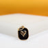 A gold-plated pendant features a raised golden heart set against a black enamel background inside a rounded rectangular frame.