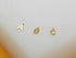 Three delicate gold initial letter charms, A, B, and C, hang on invisible fishing line necklaces against a white background.