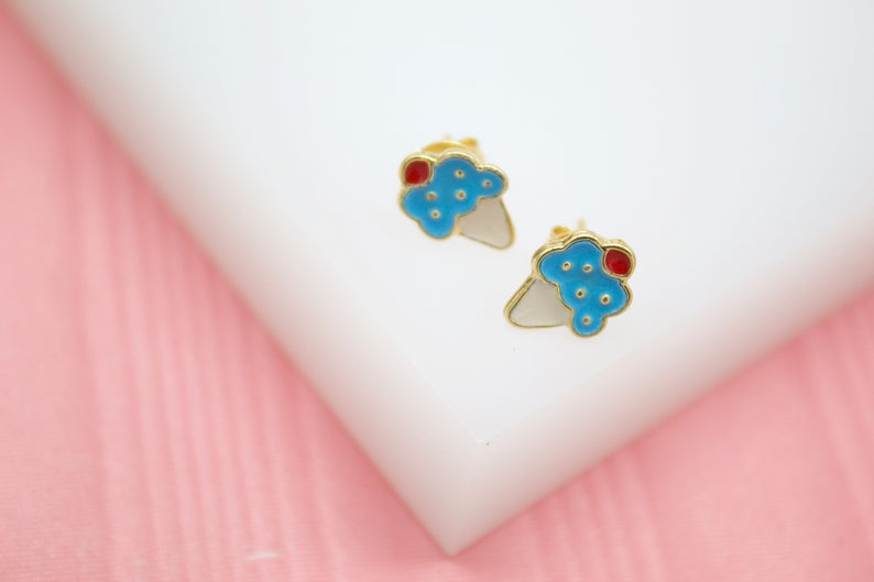A pair of gold enamel ice cream cone stud earrings rests on a white display surface.