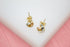 A pair of intertwined tri-color gold knot stud earrings rests on a white surface.