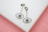 A pair of dazzling pave-set diamond evil eye drop earrings featuring sapphire blue centers rest against a white surface.