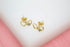 A pair of gold double heart stud earrings with sparkling cubic zirconia stones rests on a clean white surface.