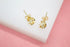 A pair of elegant gold stud earrings feature a delicate pearl nestled inside a swirling petal design.