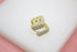 A pair of gold square huggie hoop earrings encrusted with sparkling cubic zirconia pavé rest on a white display surface.