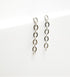 A pair of minimalist silver chain link drop earrings rests against a clean white background.