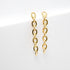 A pair of dangling gold chain-link earrings rests against a clean white background.