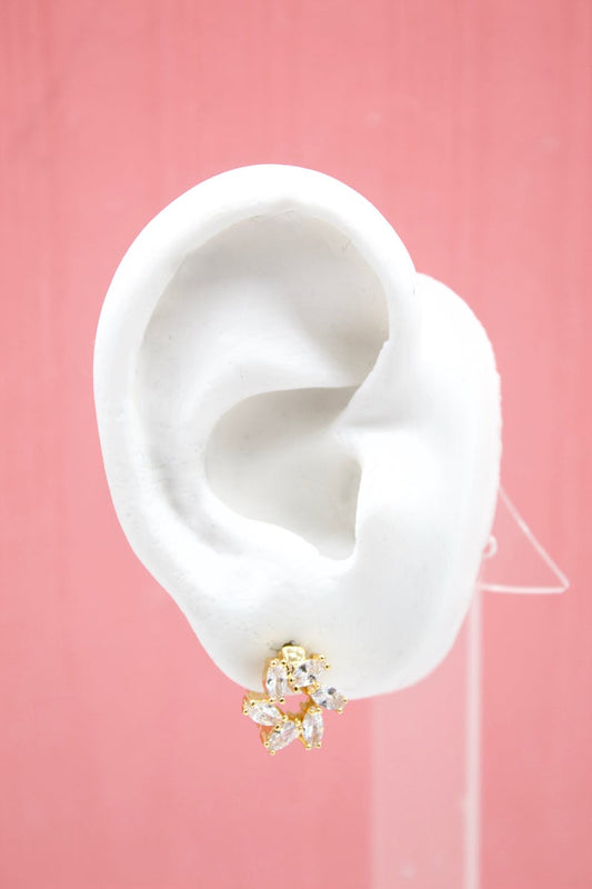 A white mannequin ear displays a gold flower stud earring sparkling with marquise-cut cubic zirconia stones.