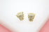 A pair of gold panther head stud earrings encrusted with sparkling cubic zirconia stones rest on a white display surface.