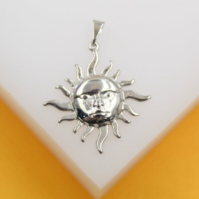 A gleaming silver sun pendant featuring a detailed face rests against a white display surface.