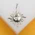 A gleaming silver sun pendant featuring a detailed face rests against a white display surface.