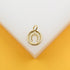 A gold horseshoe charm sits centered on a white and yellow display surface.