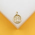A gold Tree of Life pendant rests on a clean white and yellow display surface.